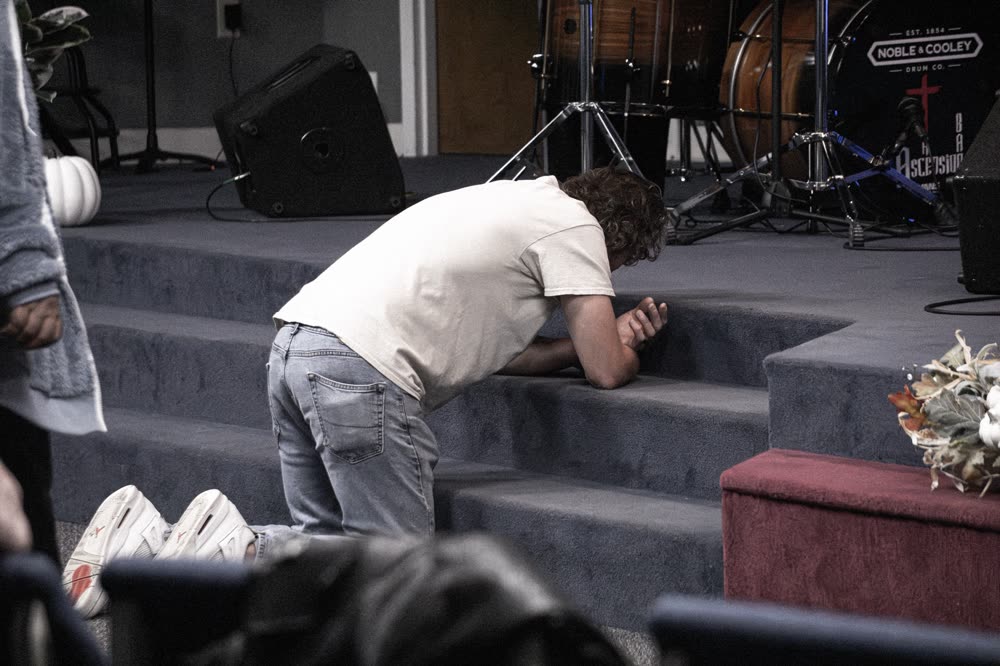 A man kneeling in prayer at the altar steps