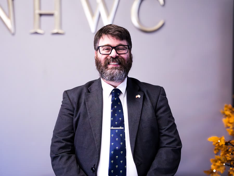 Pastor Aaron Granade smiling in a suit and tie