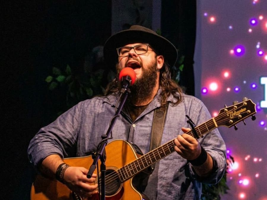 Pastor Jakob Norris leading worship with a guitar